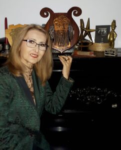 Carmen Anton alături de trofeele sale: Premiul de la Festivalul de la Mamaia, Trofeul Concursului TV "Steaua fără Nume" și Premiul Gopo.